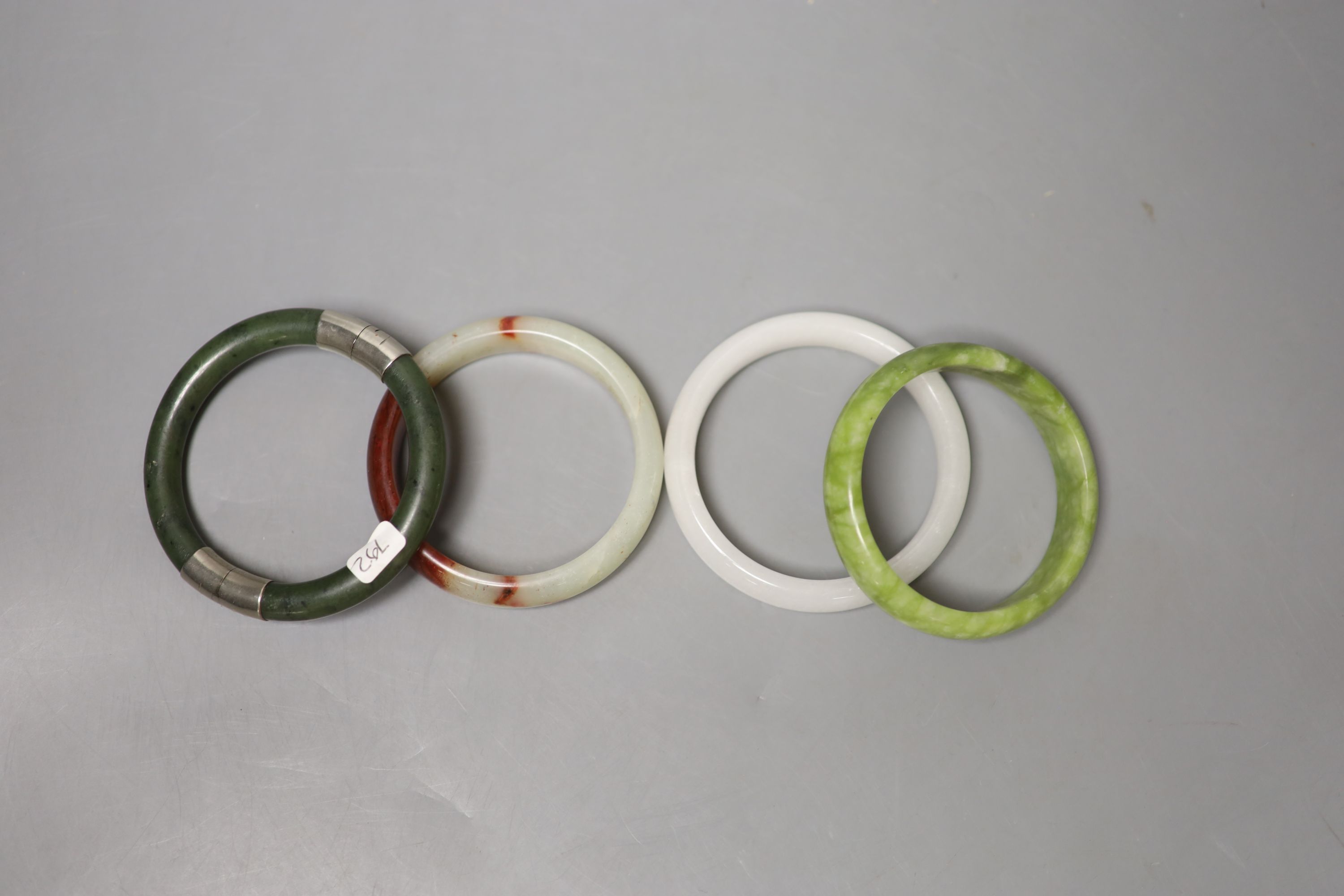 Four Chinese jade or hardstone bangles